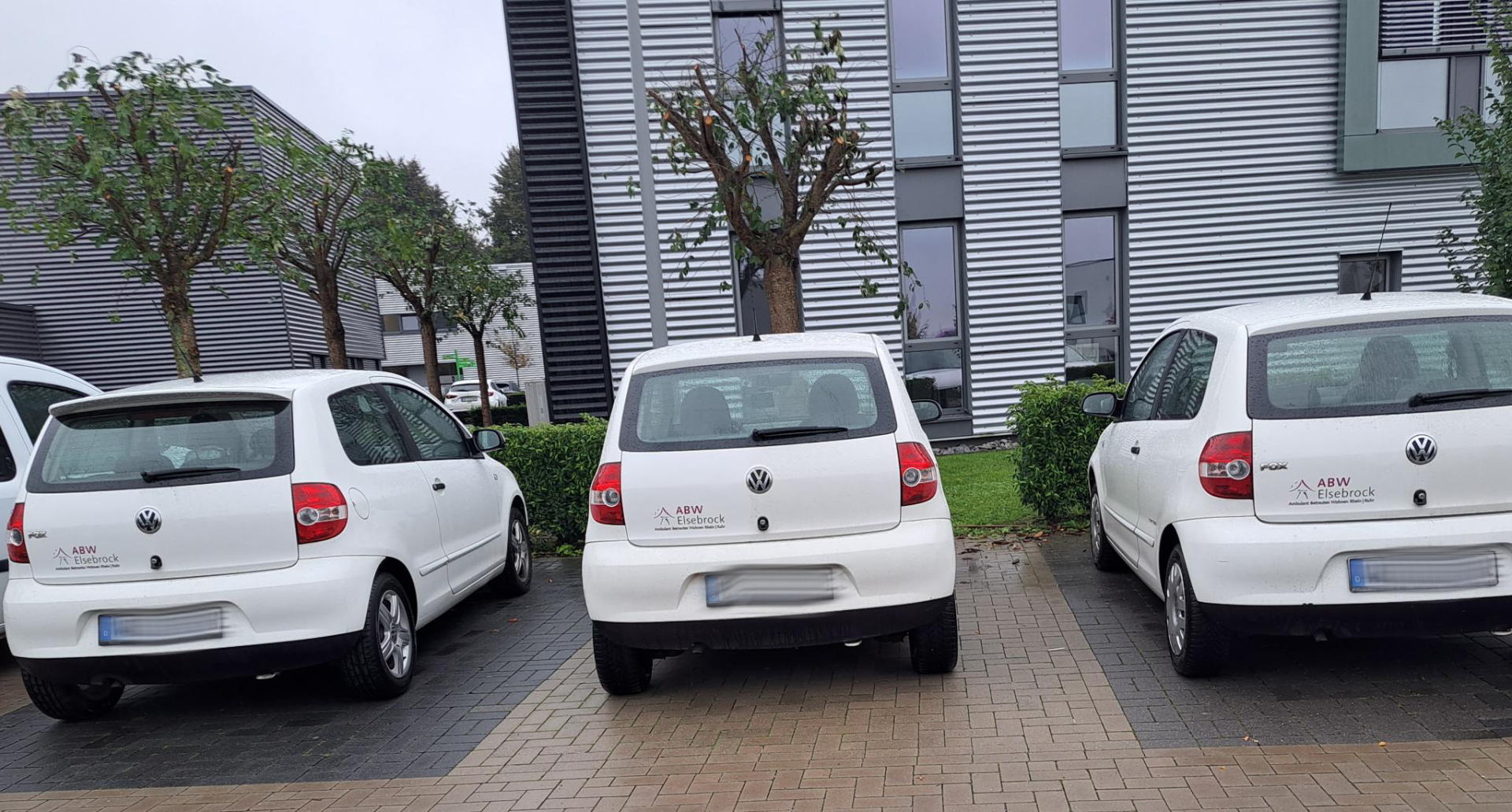 Firmenwagen vor dem Bürogebäude